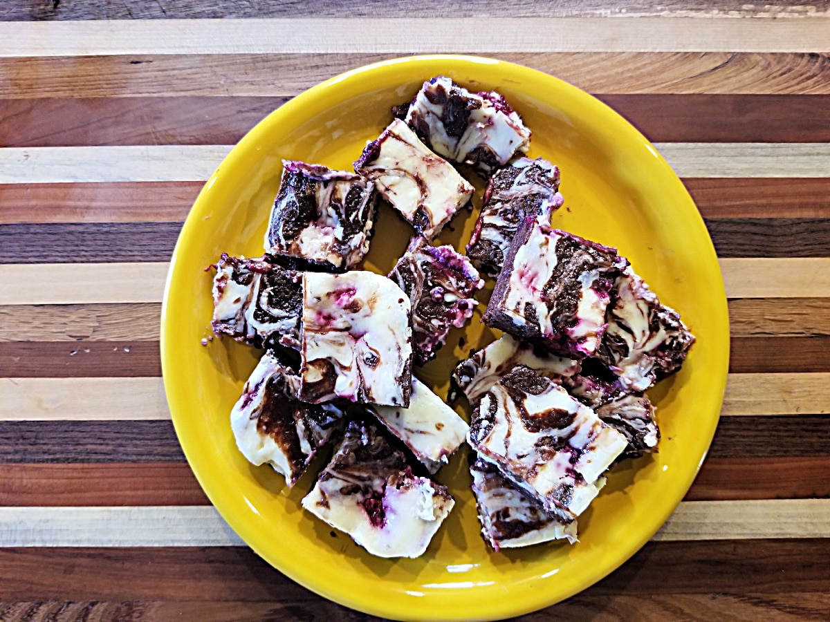 cheesecake brownies, cut, on a yellow plate